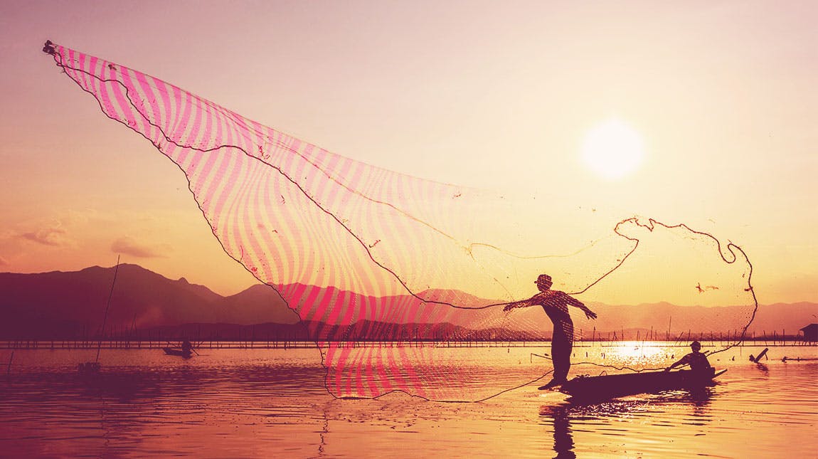 man throwing large fishing net at sunset